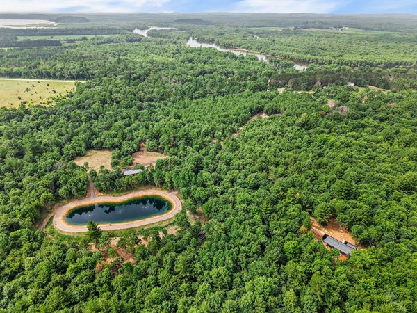 Aerial view of Oak and Ember cabins, pond, and wooded acreage