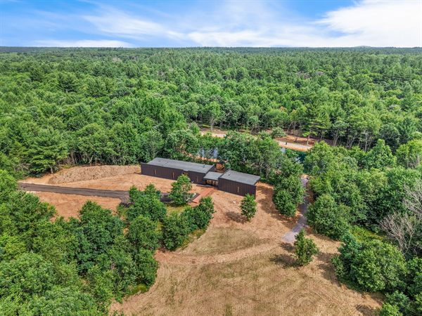Aerial view of Oak and Ember cabins, pond, and wooded acreage