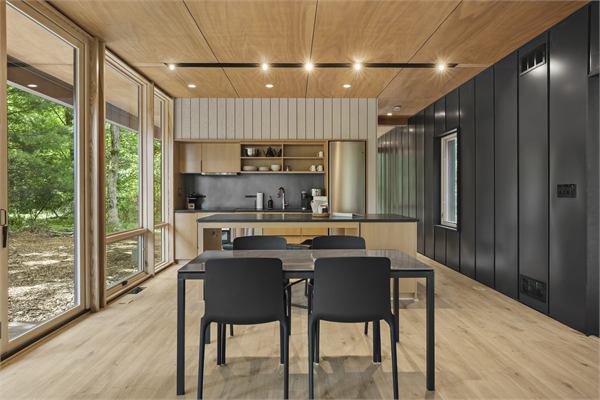 The Pines dining table and kitchen with floor-to-ceiling windows