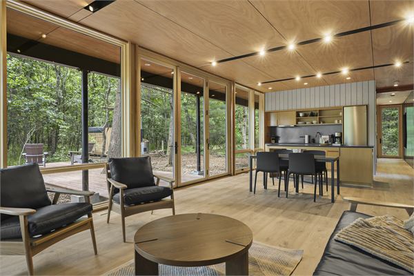The Pines open living area, dining table, and kitchen with wooded views