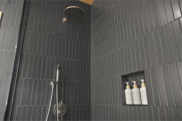 The Pines walk-in shower with dark tile
