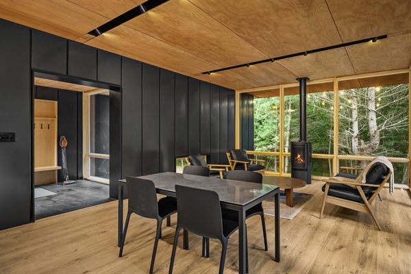 The Point open living, kitchen, and dining area with wooded views