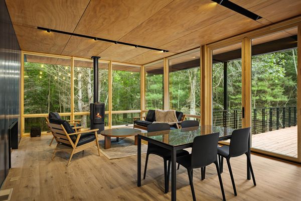 The Point open living, kitchen, and dining area with wooded views