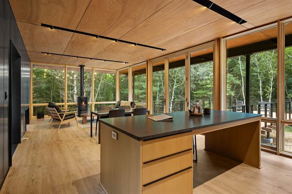 The Point open living, kitchen, and dining area with wooded views