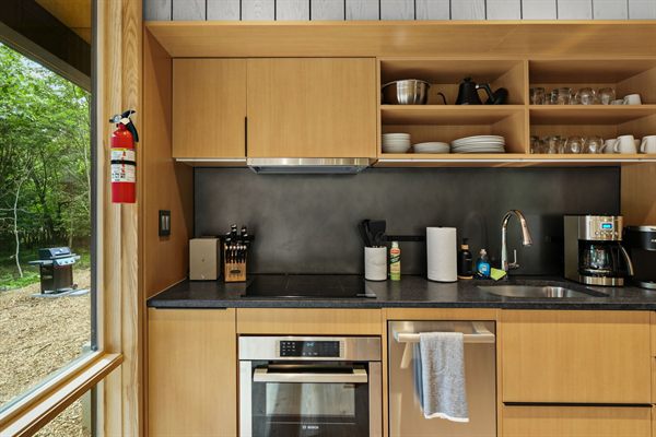 The Point open living, kitchen, and dining area with wooded views
