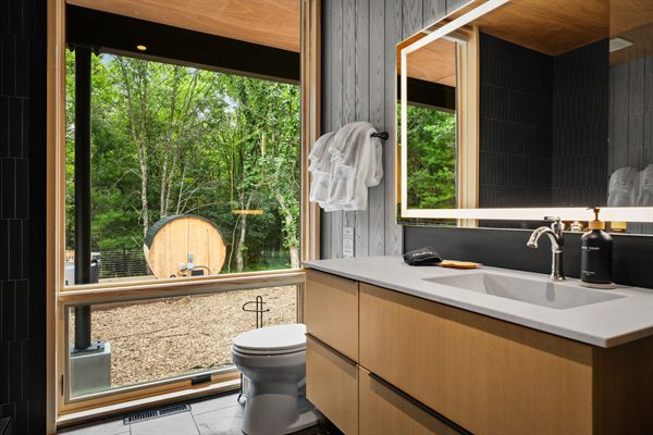 The Point modern bathroom with dark tile and warm wood vanity