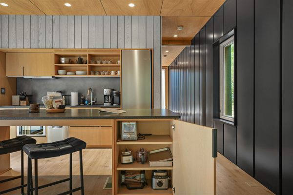 The Point open living, kitchen, and dining area with wooded views