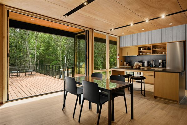 The Point open living, kitchen, and dining area with wooded views