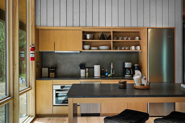 The Point open living, kitchen, and dining area with wooded views