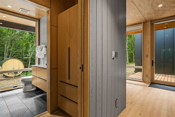 The Point modern bathroom with dark tile and warm wood vanity