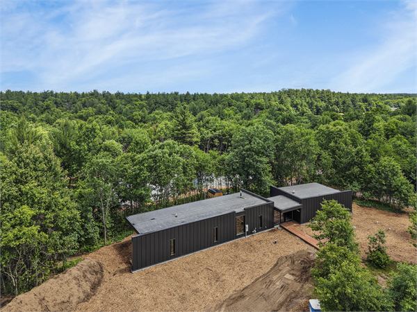 Aerial view of The Ridge cabin tucked into wooded Oak and Ember acreage