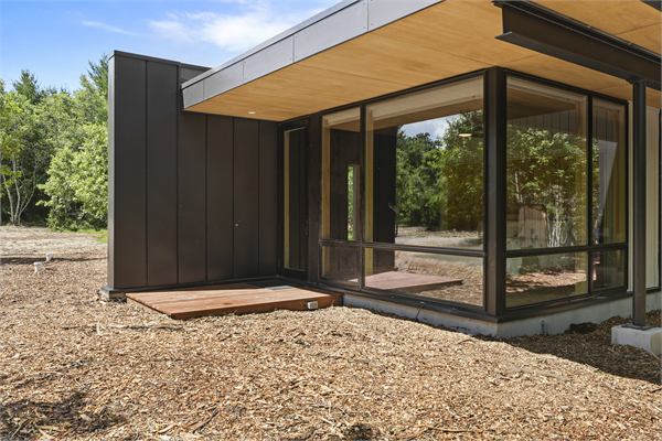 The Ridge exterior with modern glass and wooded views
